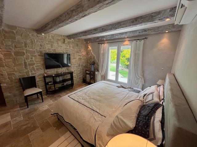 Chambre avec murs en pierre et poutres